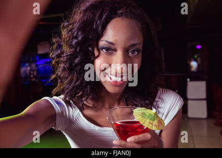 Ritratto di giovane donna avente un cocktail Foto Stock