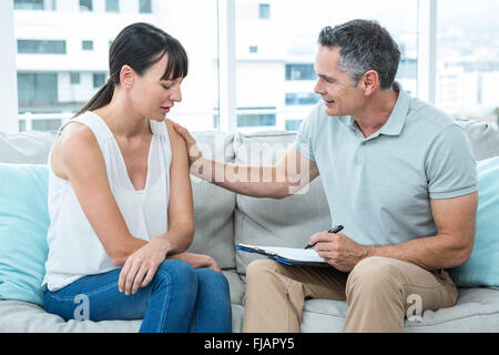 Terapista consolante di una donna Foto Stock