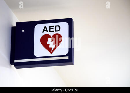 Defibrillatore semiautomatico AED segno su una parete in un aeroporto. Foto Stock