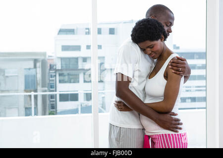 Incinta giovane cuddling ogni altro Foto Stock