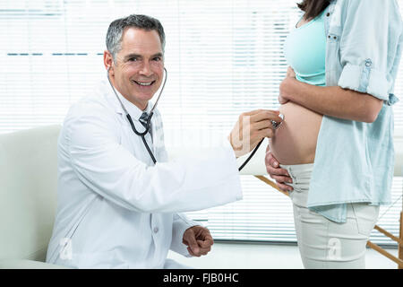 Medico esaminando una donna in stato di gravidanza Foto Stock