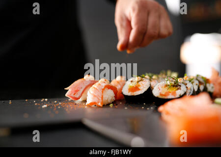 La formazione di sushi. I passaggi per la creazione di sushi con salmone crudo. Maestro di sushi preparazione di sushi in un ristorante giapponese . Foto Stock