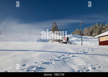 Macchina rendendo la neve su una pista da sci Foto Stock
