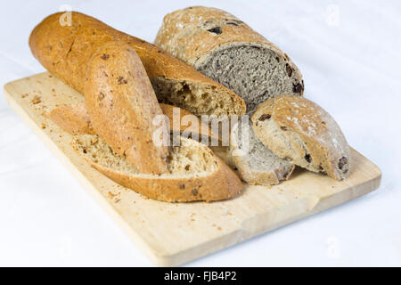 Tagliare il pane su una tavola di legno, fondo bianco Foto Stock