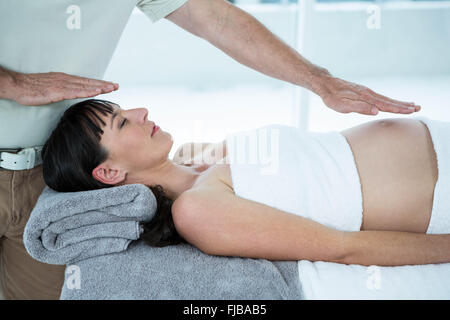 Donna incinta ricevere un massaggio da massaggiatore Foto Stock