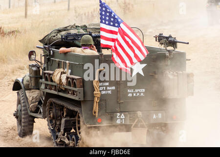 Guerra e pace show, Inghilterra. Seconda guerra mondiale rievocazione. American metà carrello, a stelle e strisce di volo, guida lontano, rendendo la polvere Foto Stock