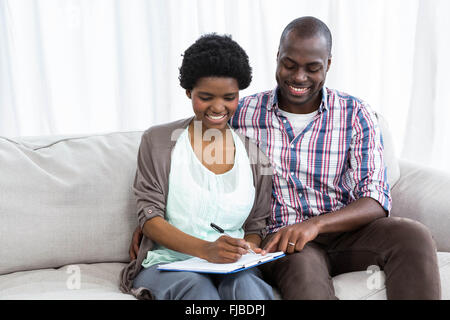 Incinta matura la scrittura su un blocco note Foto Stock