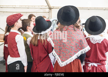 Carmarthen, Galles, Regno Unito. 1st marzo 2016. Carmarthen, Galles, Regno Unito. 1st marzo 2016. Ragazzo, ragazzi, ragazza, ragazze, Bambini, bambini, alunni, studenti, dalla scuola di Nantgaredig in costume nazionale del Galles cantare canzoni in gallese a Guildhall Square, Carmarthen, Carmarthenshire, Galles, Regno Unito. Credit: Paul Quayle/Alamy Live News Foto Stock