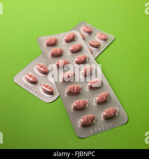 Statine, i farmaci ipocolesterolemizzanti, nel confezionamento di blister su sfondo verde Foto Stock