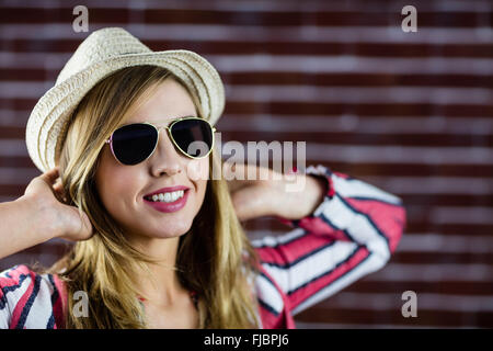 Donna sorridente con occhiali da sole Foto Stock