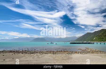 Barca da pesca al molo e il mare turchese, cielo nuvoloso, Jackson Bay, West Coast, Tasmania, Isola del Sud della Nuova Zelanda Foto Stock