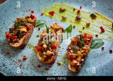 Cibo vegan: bruschetta con peperone, pomodori, rucola, il timo e le foglie di basilico Foto Stock