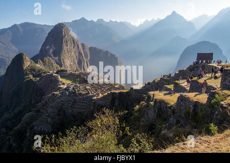 Machu Picchu in luce mattutina con i turisti, Huayna Picchu dietro, regione di Cusco, Perù Foto Stock