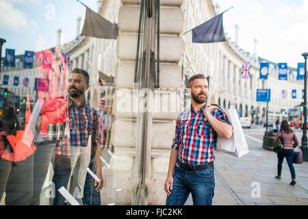 Hipster uomo shopping nelle strade di Londra Foto Stock
