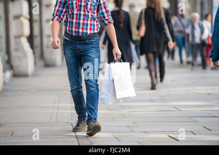 Irriconoscibile uomo con le borse della spesa in strada, vista posteriore Foto Stock