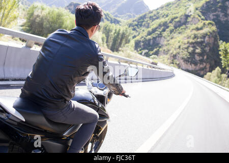 Giovane uomo cinese riding motociclo Foto Stock