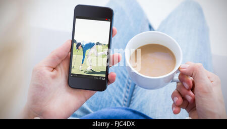 Immagine composita della donna con il suo telefono cellulare e la coppa di ritegno del caffè Foto Stock