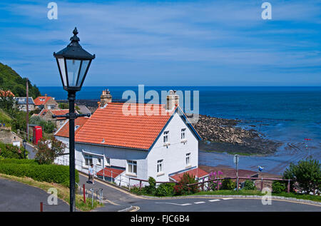Ingresso per la festa del villaggio costiero di Runswick Bay, North Yorkshire, con la vecchia lampada posta in primo piano, England Regno Unito Foto Stock