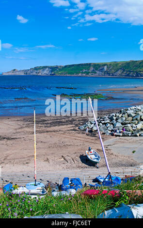 Barche ormeggiate sul bordo della spiaggia di sabbia a Runswick Bay, caldo giorno d'estate, North Yorkshire Heritage Coast Inghilterra, Regno Unito Foto Stock