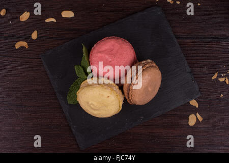 Colorati macarons francese su sfondo di legno Foto Stock