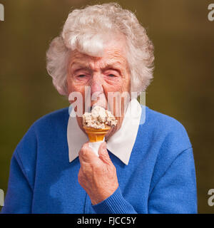 Una signora anziana di mangiare un gelato nel Regno Unito Foto Stock