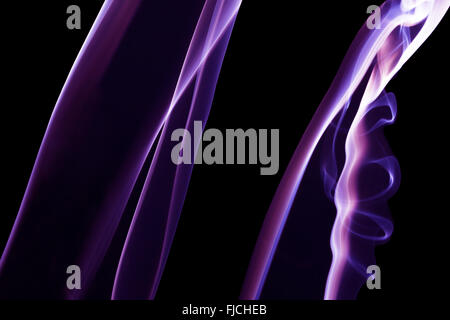 Viola le linee di vapore sullo sfondo nero. Foto Stock