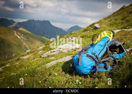 Zaino o zaino equilibrata contro una roccia sulla sommità della cima di una montagna Foto Stock