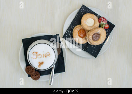 La prima colazione con cappuccino, latte di soia e biscotti Foto Stock