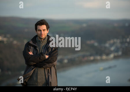 Giovane uomo di fronte a Rheine river, Germania, usando la mappa Foto Stock