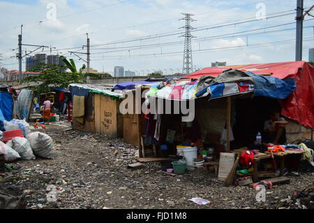 Tela utilizzata come tetto di casa-baracca con alti grattacieli dietro, Jakarta, Indonesia Foto Stock