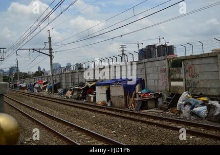 Tela utilizzata come tetto di casa-baracca con alti grattacieli dietro, Jakarta, Indonesia Foto Stock