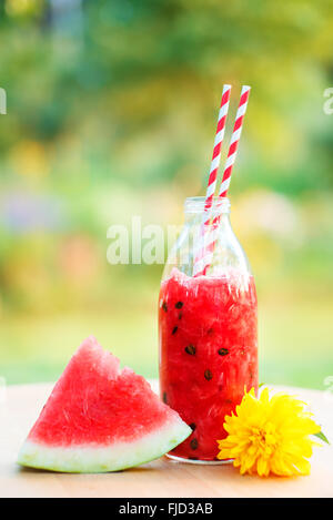 Anguria dolce detox drink per le calde giornate estive. Profondità di campo, concentrarsi sulla bottiglia Foto Stock