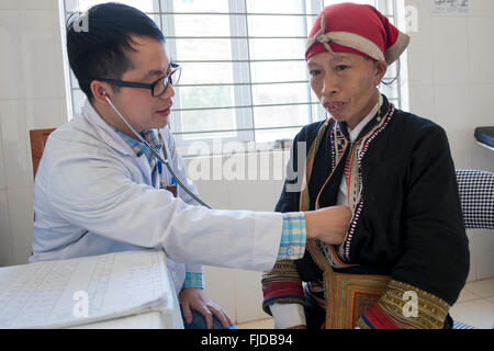 Un medico esamina una donna dalla tribù Dzao presso il divieto Khoang può Ho ospedale nel nord del Vietnam Foto Stock