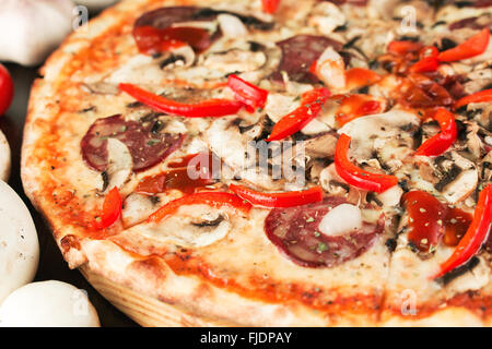 La Pizza con il peperone verde, la cipolla e la salsiccia vicino. Profondità di campo Foto Stock