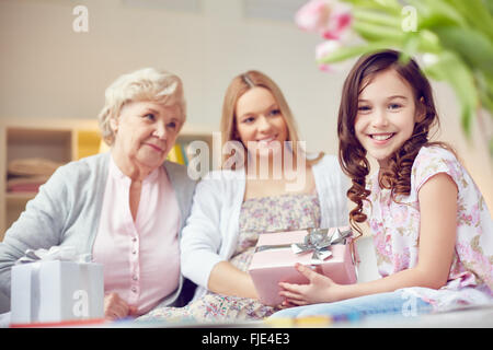 Ragazza carina congratularsi con sua madre e nonna con la festa della mamma Foto Stock