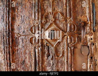 Ferro battuto decorativo sulla vecchia porta di legno ingresso alla chiesa di San Michele a Irstead, Norfolk, Inghilterra, Regno Unito. Foto Stock