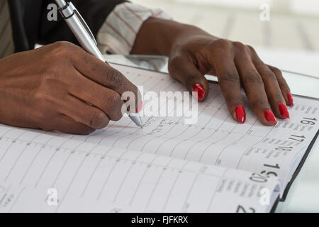 La donna la scrittura di pianificazione nel diario del calendario Foto Stock