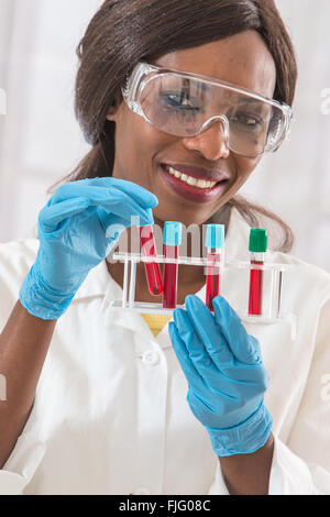 Femmina assistente di laboratorio studia il campione di sangue per analisi Foto Stock