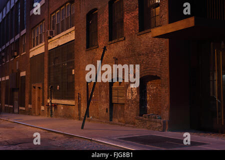 Water Street di notte nel quartiere lungomare di DUMBO di Brooklyn di notte guardando ad ovest verso il ponte di Manhattan e Foto Stock