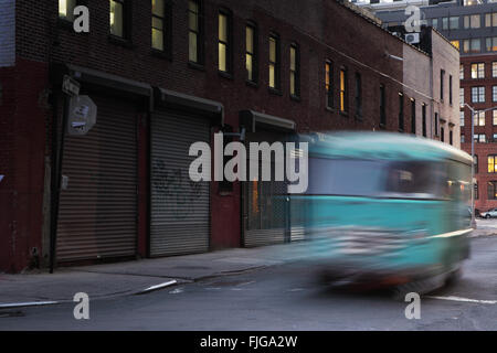 Plymouth Street di notte nel quartiere lungomare di DUMBO di Brooklyn a notte con una verde van guidando lungo la strada Foto Stock