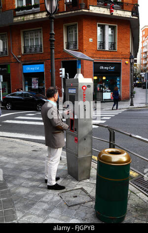 Uomo che acquista il biglietto utilizzando un parchimetro a energia solare che fa parte del sistema di parcheggio pubblico su strada OTA-TAO, centro di Bilbao, Paesi Baschi, Spagna Foto Stock