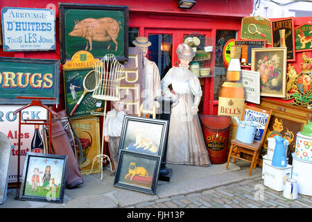 Vintage merchandise con quadri stampe e segni di vendita lungo Portobello Road Foto Stock