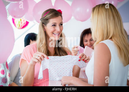 Donna che dono a donne in stato di gravidanza amico su baby shower party Foto Stock