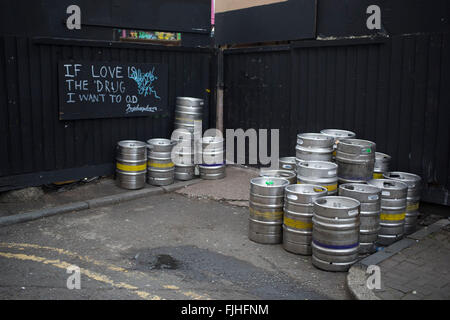 Vuoto barili di birra al di fuori di un bar a Hoxton, Londra, Regno Unito. Questa scena contiene anche alcune delle locali ironico street art graffiti. Lettura: Se amore erano il farmaco, voglio OD. Foto Stock