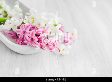 Bianco e rosa fiori di giacinto in una ciotola di legno .Spa impostazione con fiori delicati Foto Stock