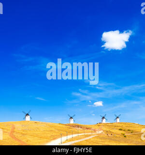 Cervantes Don Chisciotte mulini a vento, rurale campi verdi, blu cielo e la nuvola piccola in Consuegra. Castiglia La Mancha, in Spagna, Europa Foto Stock