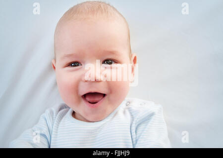 Tre mesi di età bambino giacente a letto Foto Stock