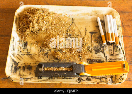 Effettuare manualmente le sigarette con la macchina di tabacco. Foto Stock