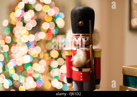 Un Natale schiaccianoci con luci ad albero in background Foto Stock