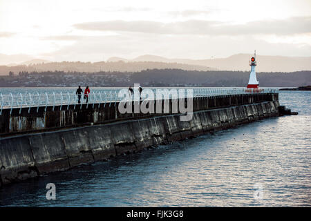 La gente che camminava sul frangiflutti a Ogden Point - Victoria, Isola di Vancouver, British Columbia, Canada Foto Stock